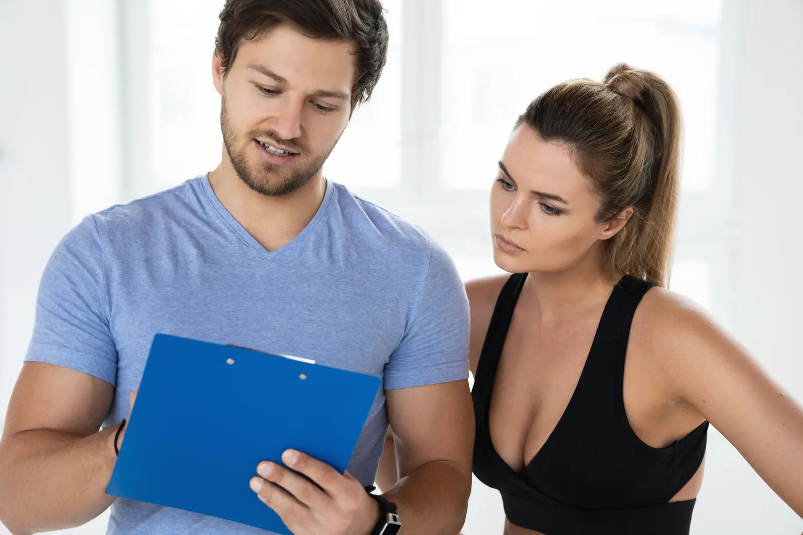 Personal fitness instructor writing a training and diet plan for a client, as a program is mapped out