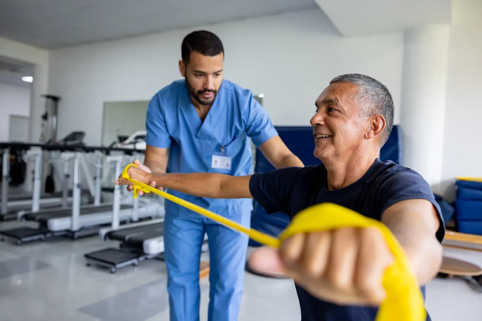 Man working through physical therapy exercises with a resistance stretch band