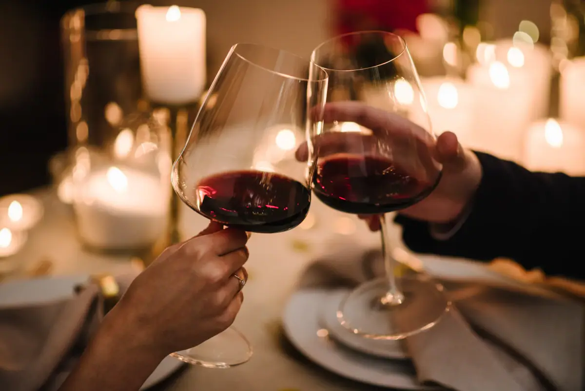 Couple toasting with wine glasses at a candlelit dinner date
