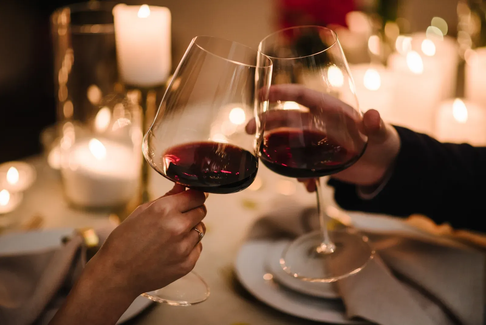 Couple toasting with wine glasses at a candlelit dinner date