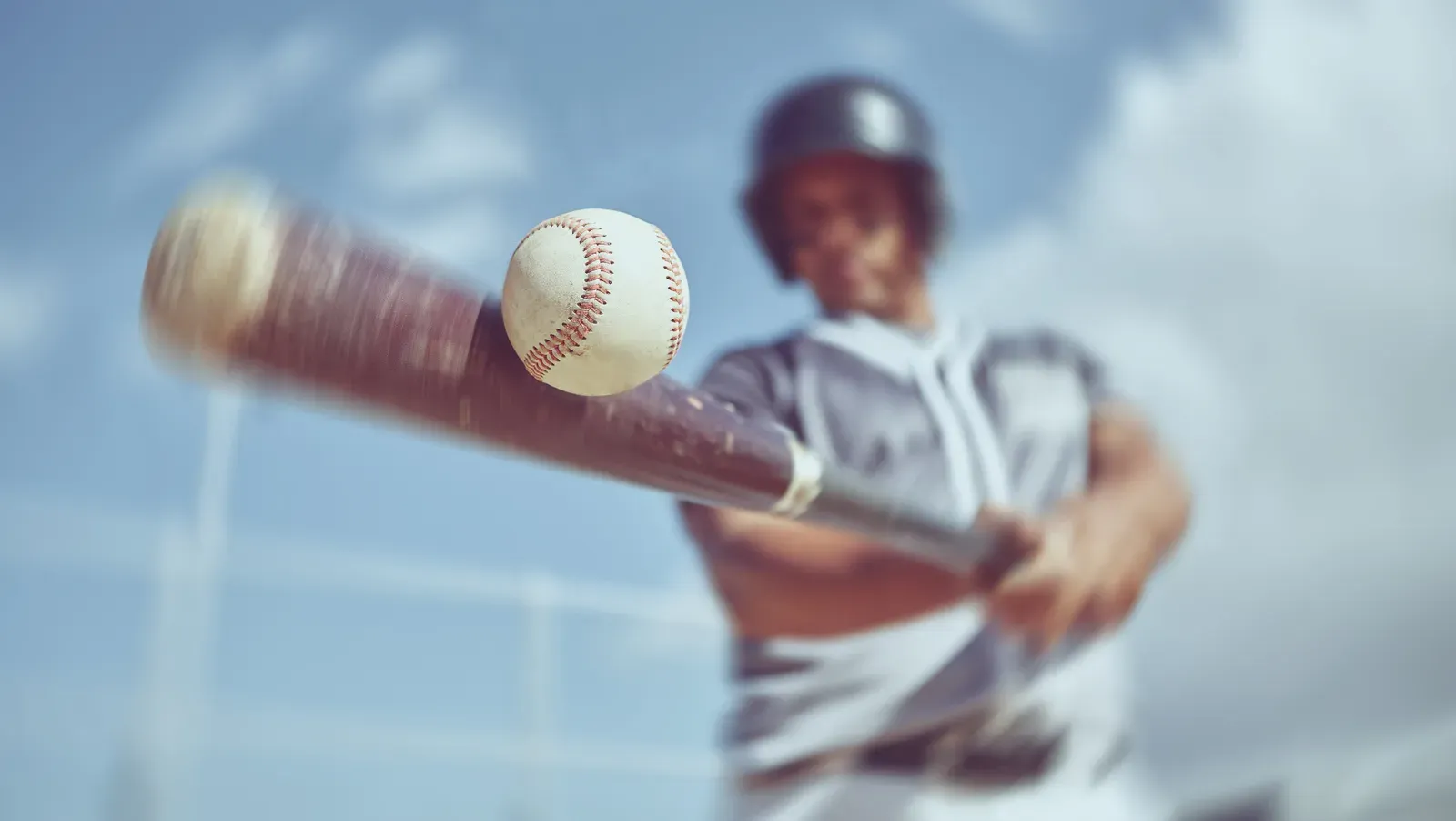 Baseball player mid-swing at the plate, hips rotated through contact