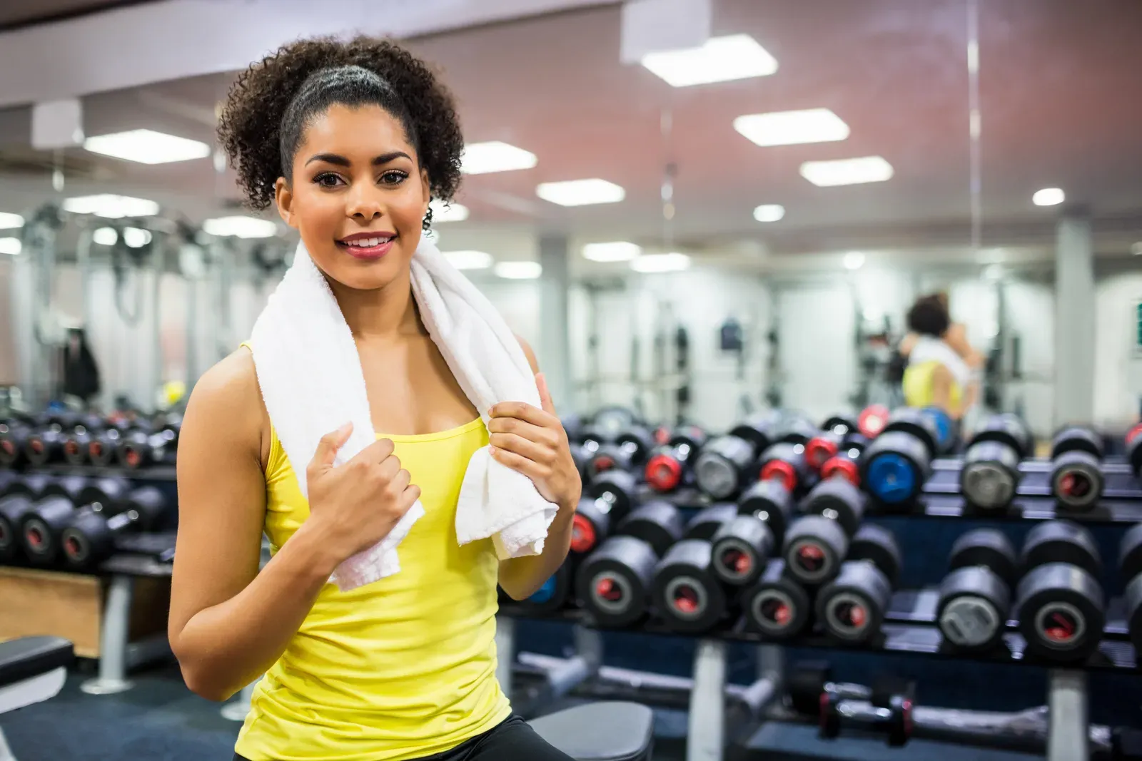Fit woman working out in a weights room, one option when deciding between cardio and weights first