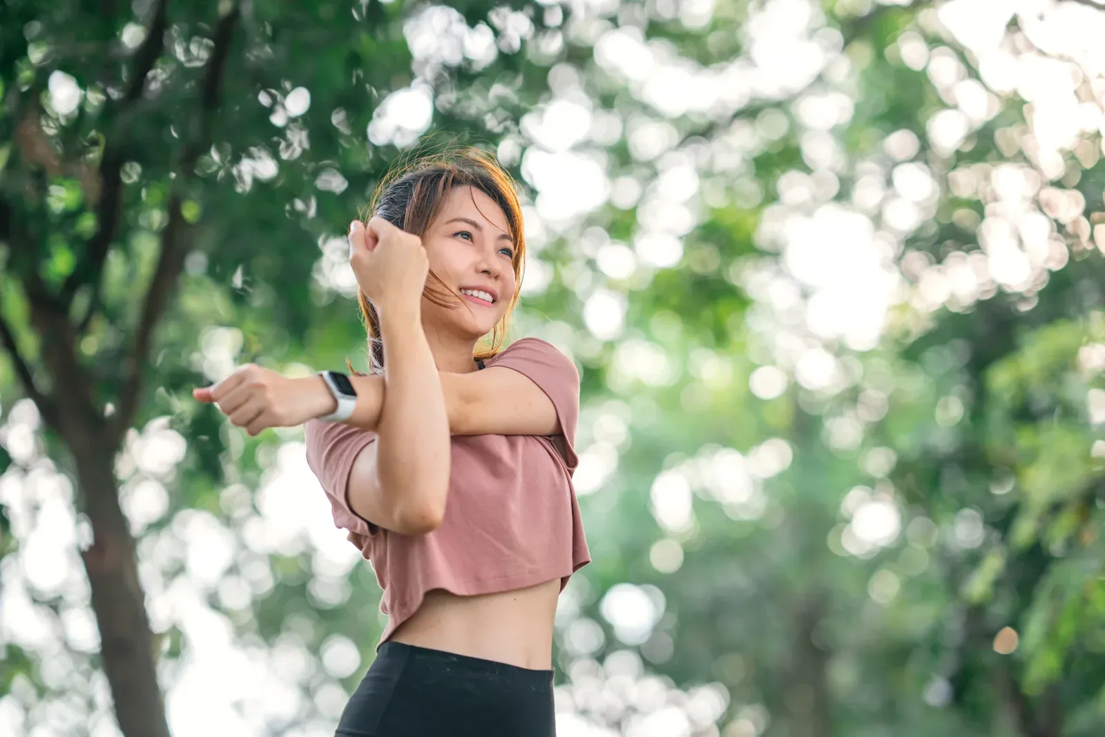 Woman stretching her arms to warm up before a run or workout, a gentle start for training with asthma