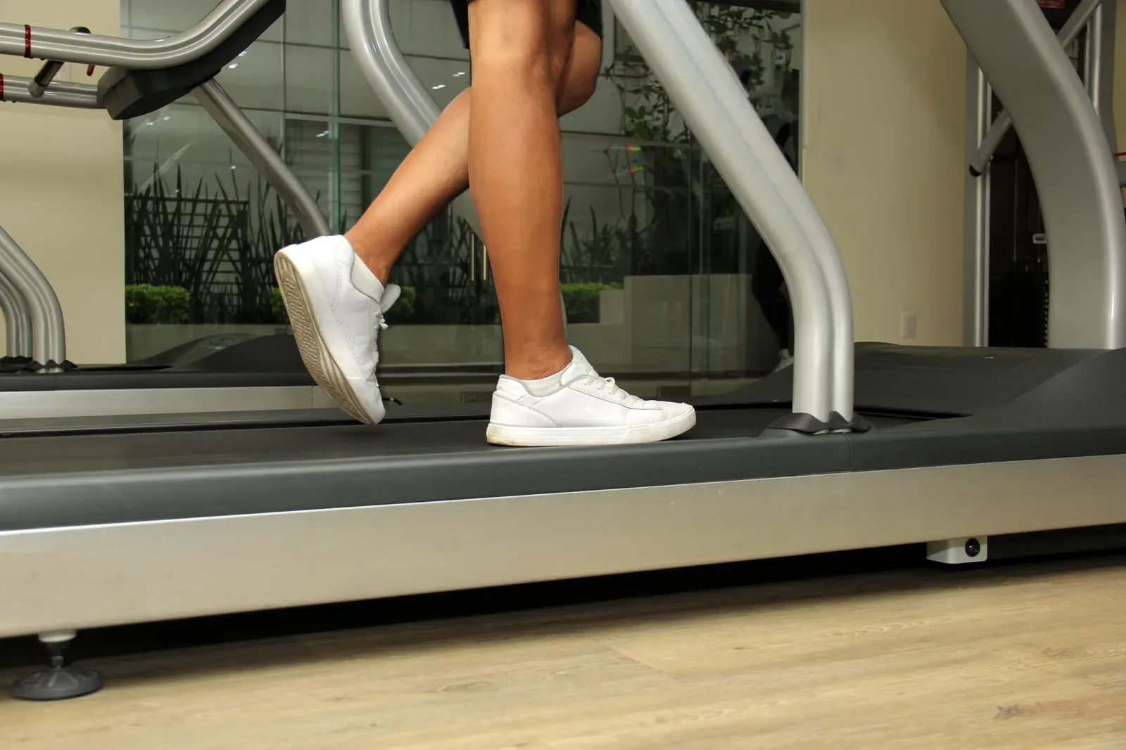 Man exercising on a treadmill in a gym, steady cardio often paired with strength work to help lower A1C