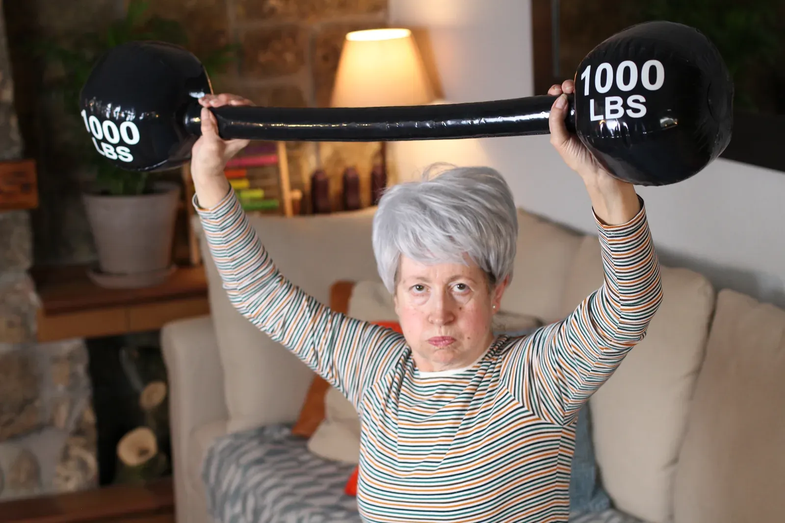 Older woman lifting heavy weights, a strength habit that supports body composition goals after 50