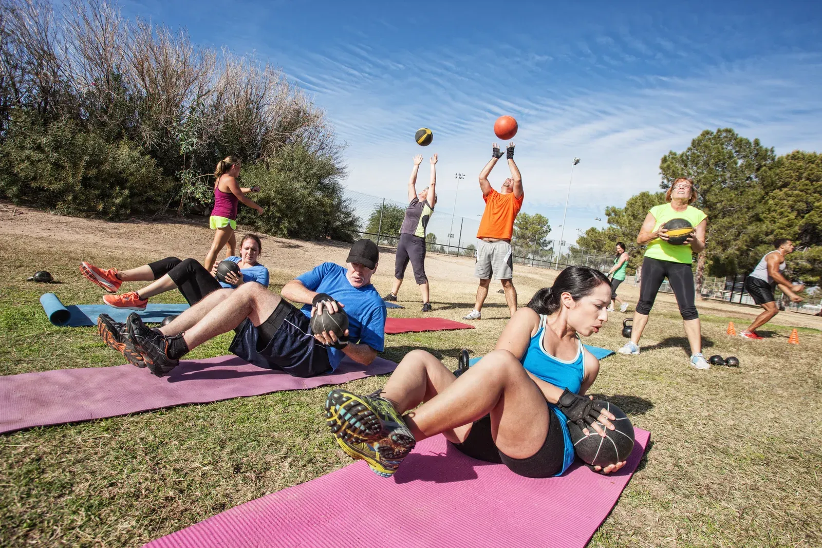 Focused athlete performing an intense circuit exercise with a coach nearby