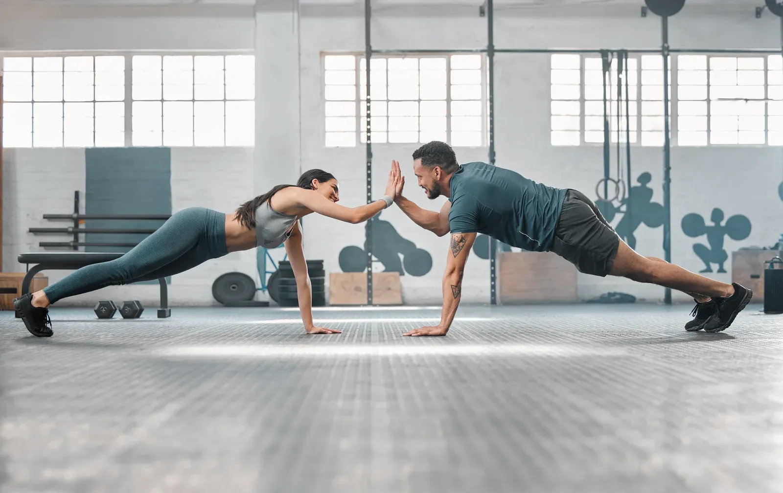 Couple exchanging a high five between sets during a shared workout