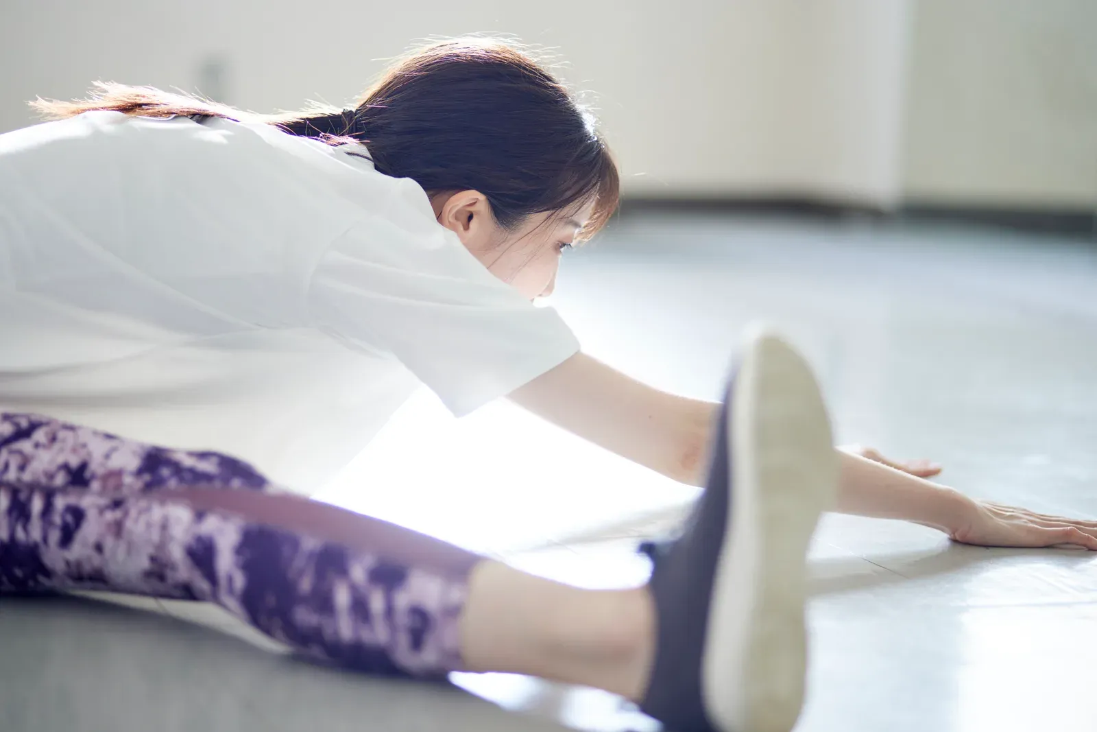 A teenage dancer practicing a controlled single-leg landing during a conditioning session