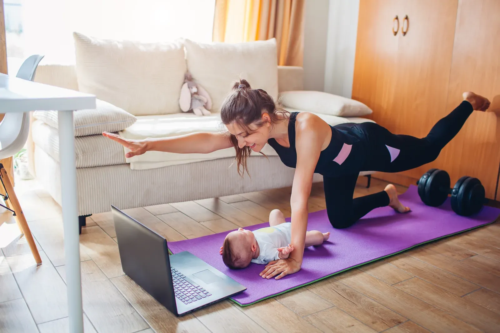 New mother practicing a controlled core breathing exercise on a bench with a coach nearby