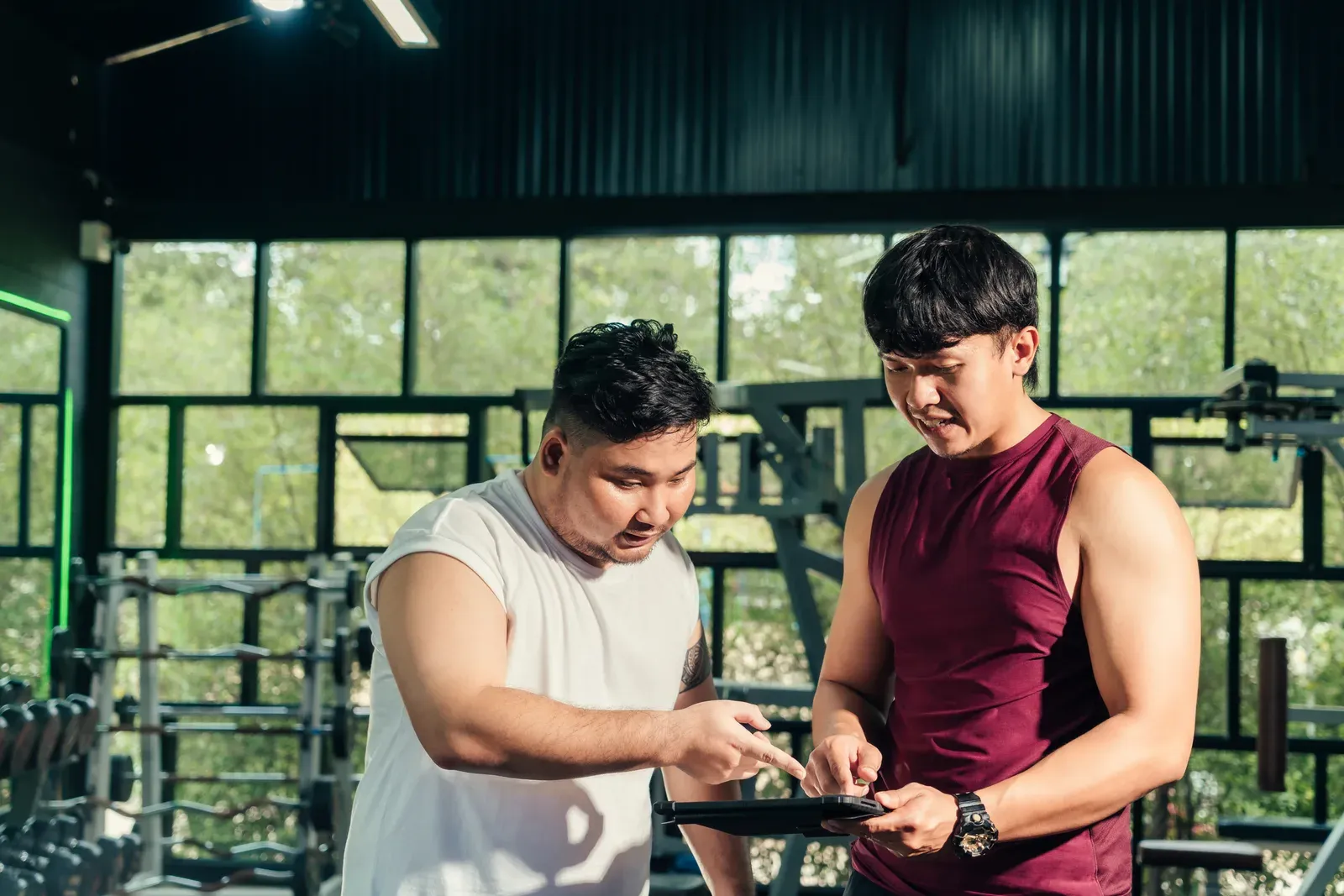 A lifter checking a written workout plan on a phone between sets