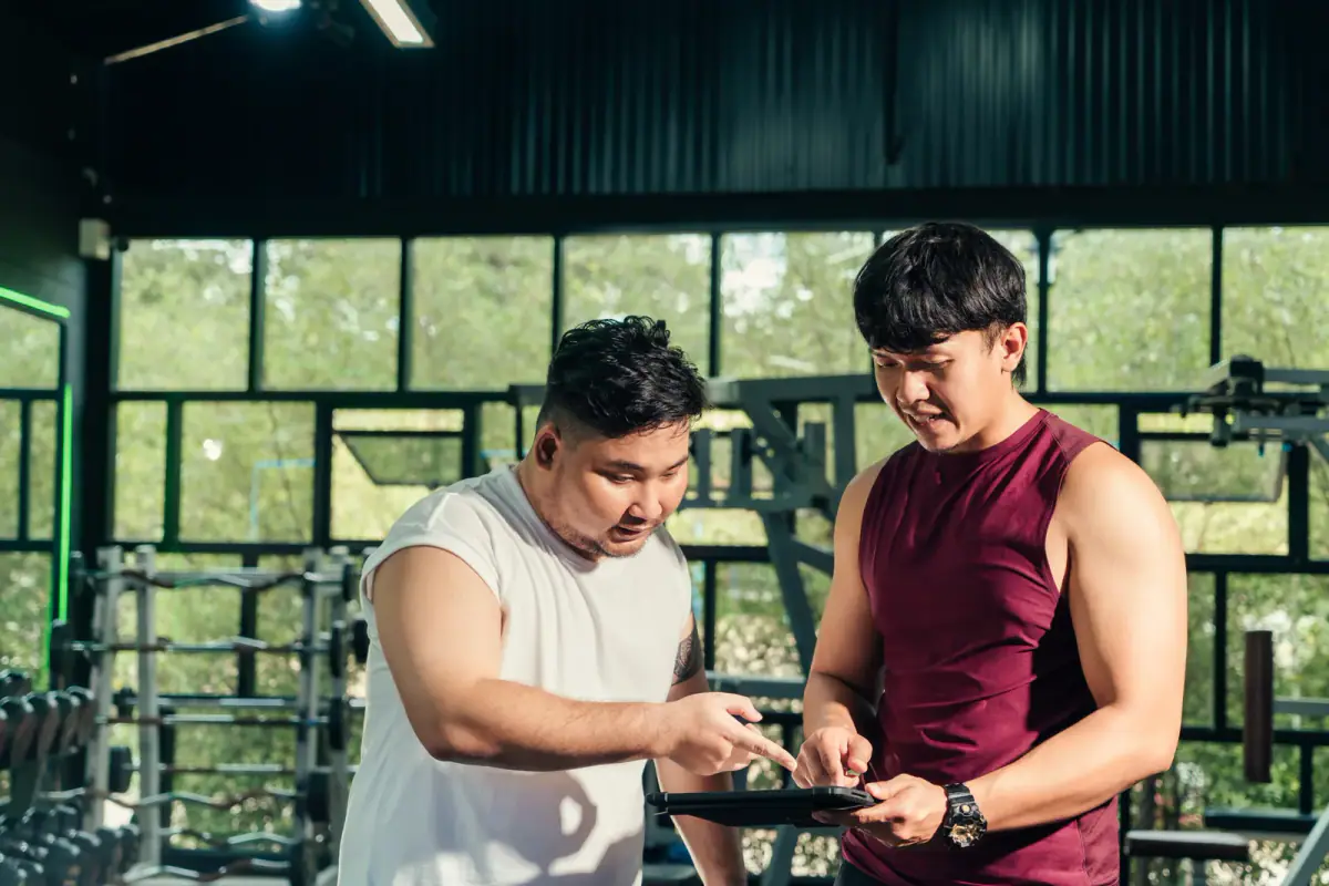 A lifter checking a written workout plan on a phone between sets