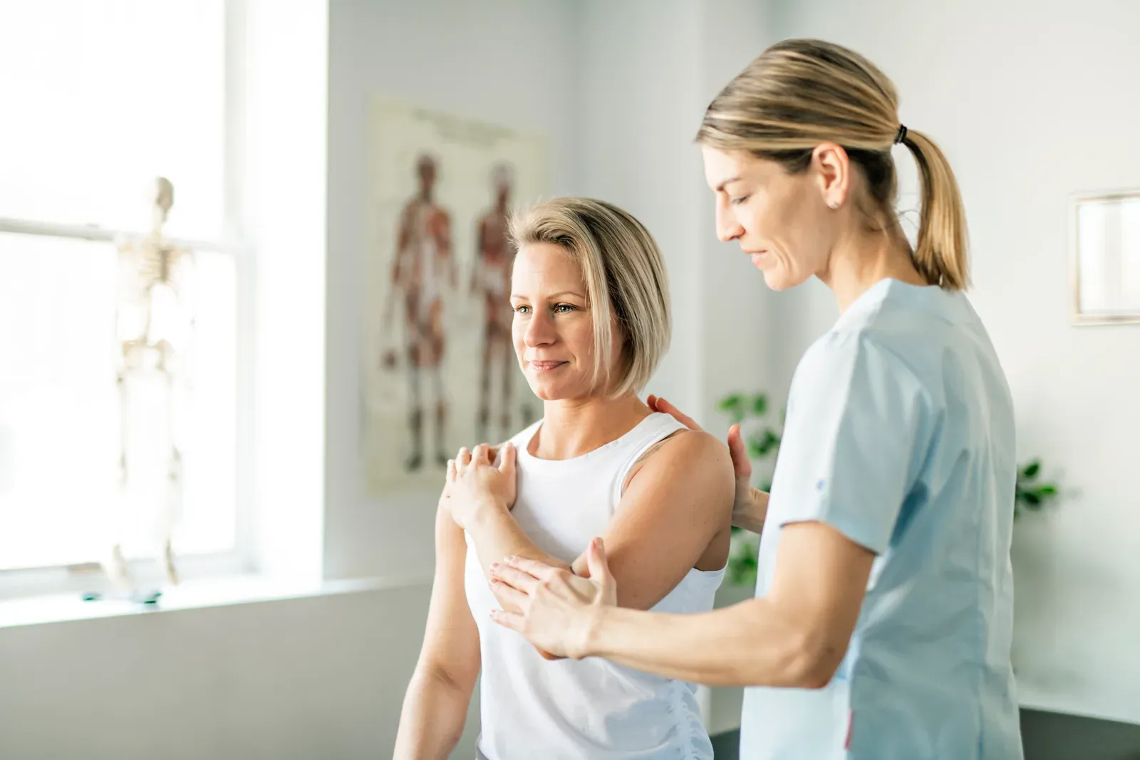 Physiotherapist working one on one with a woman client in a rehabilitation setting