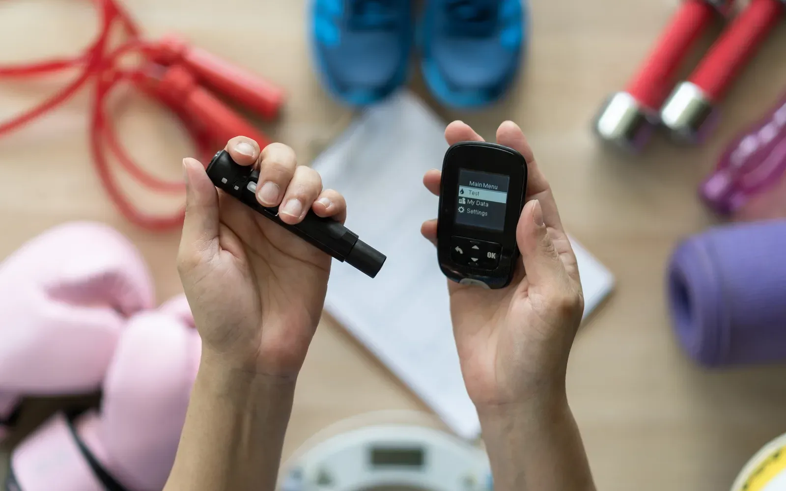 Blood sugar test being taken with exercise equipment in the background