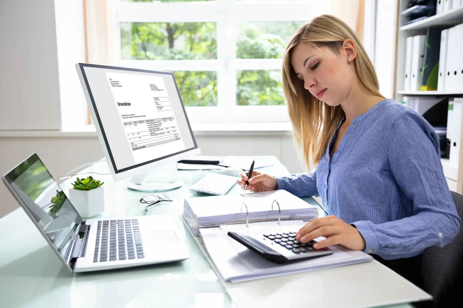 A person photographing a paper receipt beside a laptop to submit a claim