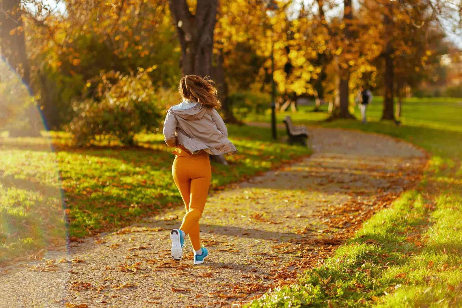 Woman in fitness clothes jogging in a park, a steady routine that can support addiction recovery