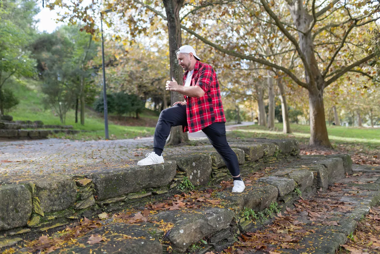 Man doing step-ups on stone steps in a park, a functional leg exercise for building strength with hip arthritis