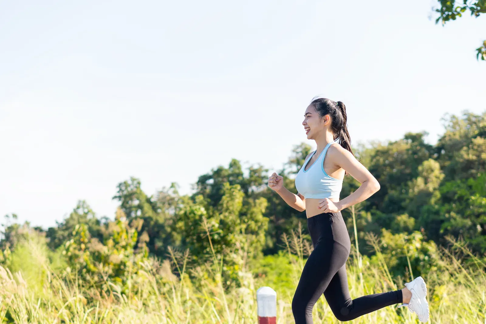 Woman running in a park in the evening, exercise that may help lift energy levels