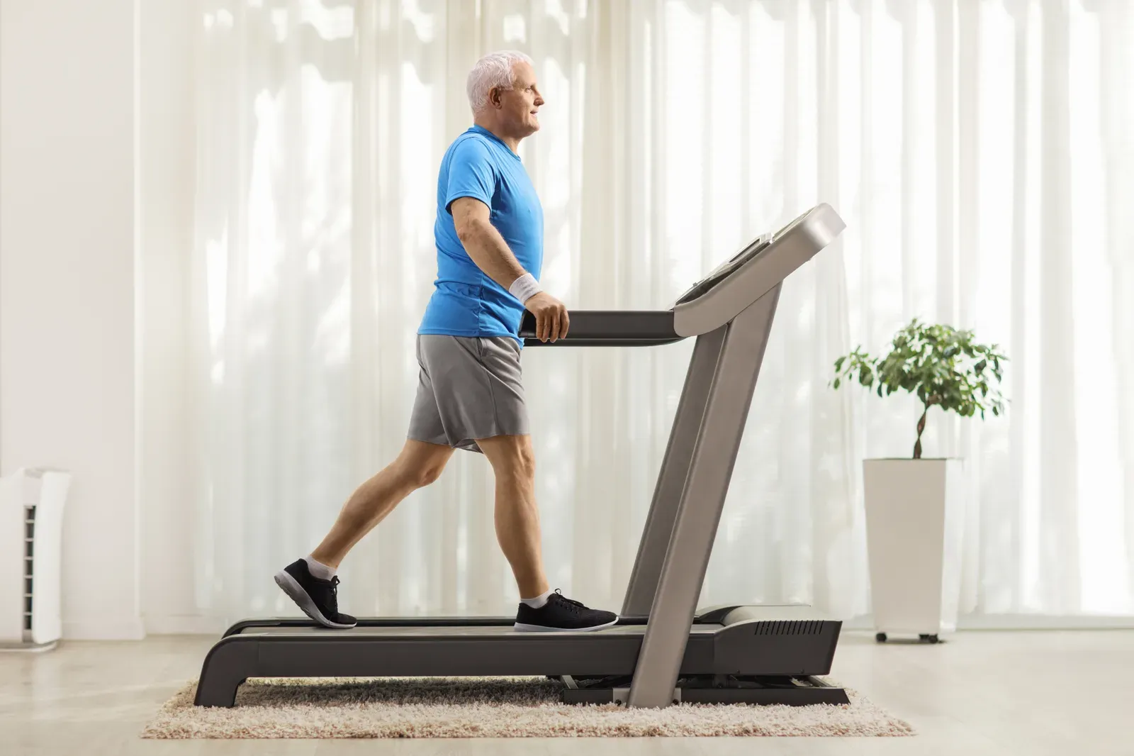 Mature man walking on a treadmill, a steady routine that can be built around leg pain