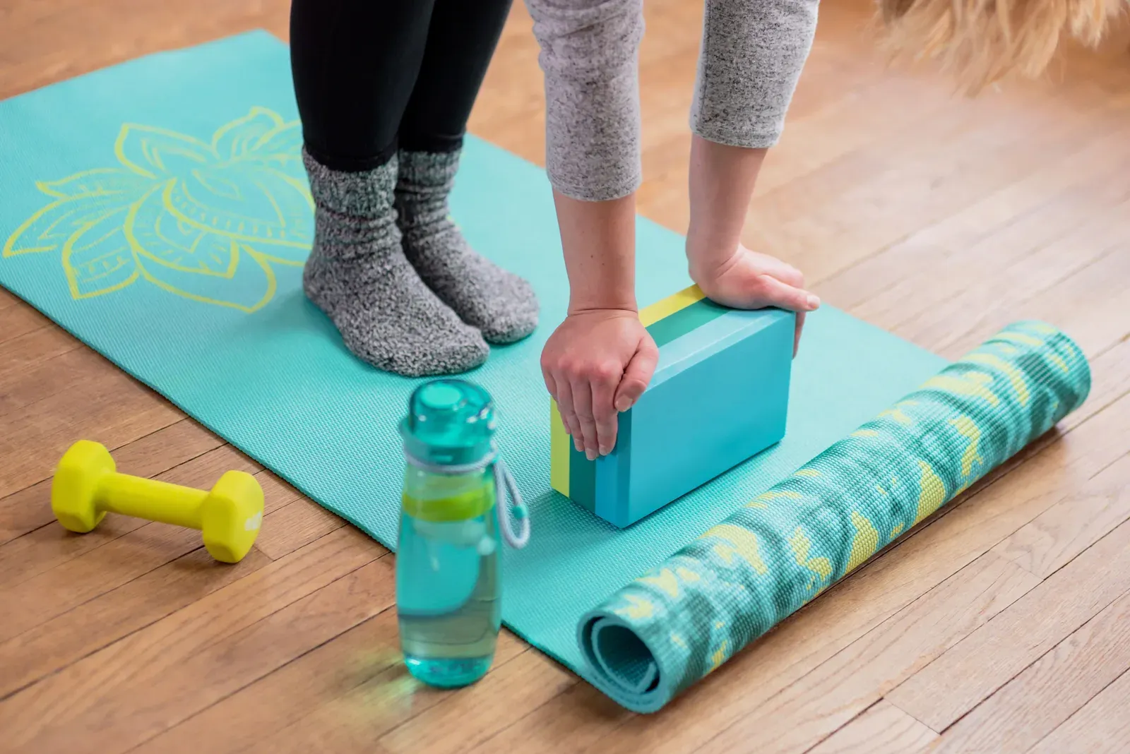 Girl with her hands on a yoga block stretching, gentle movement that can be adapted around symptoms