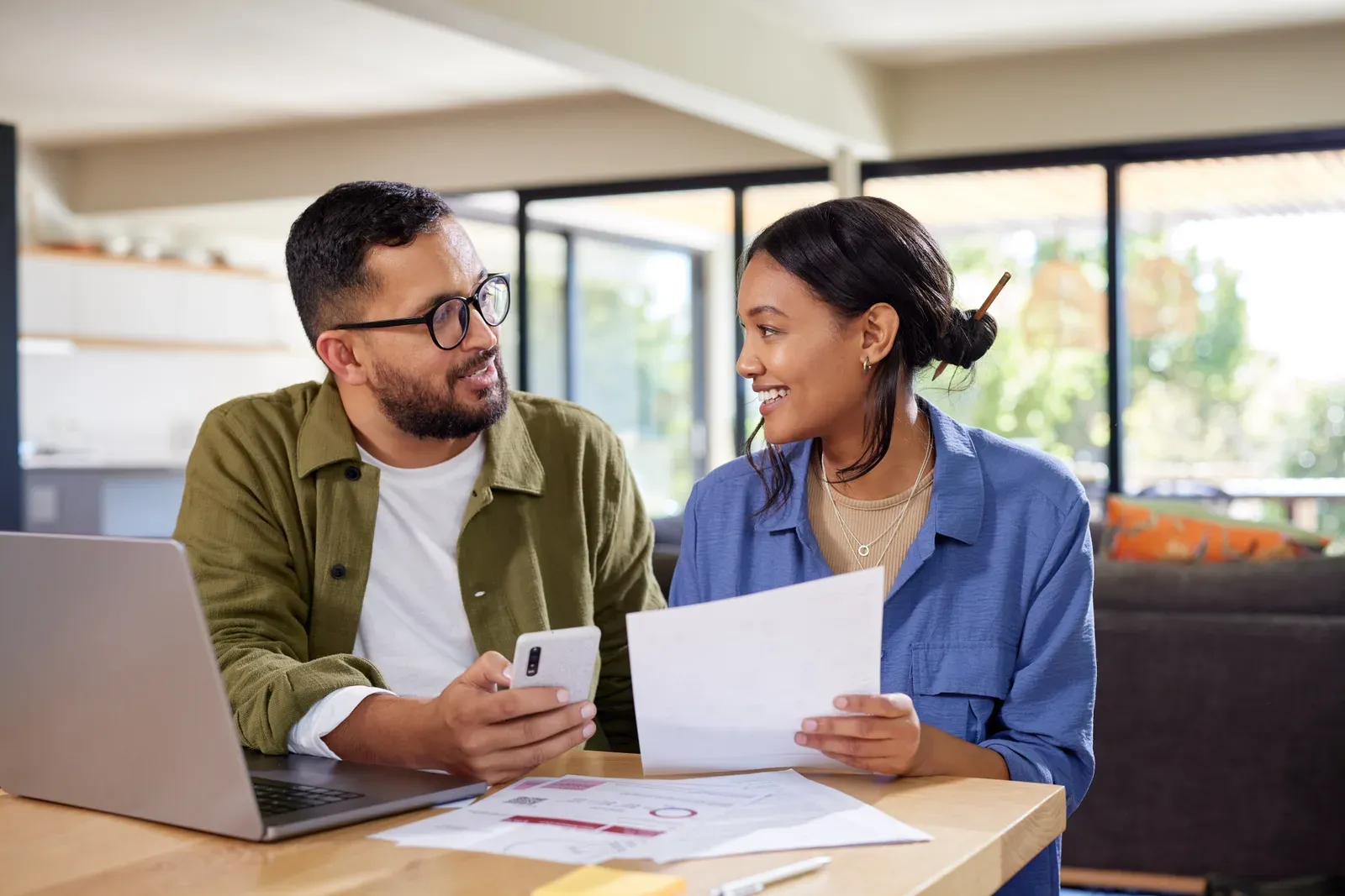 Couple discussing home finances while checking bills, a step when weighing payment plans for training