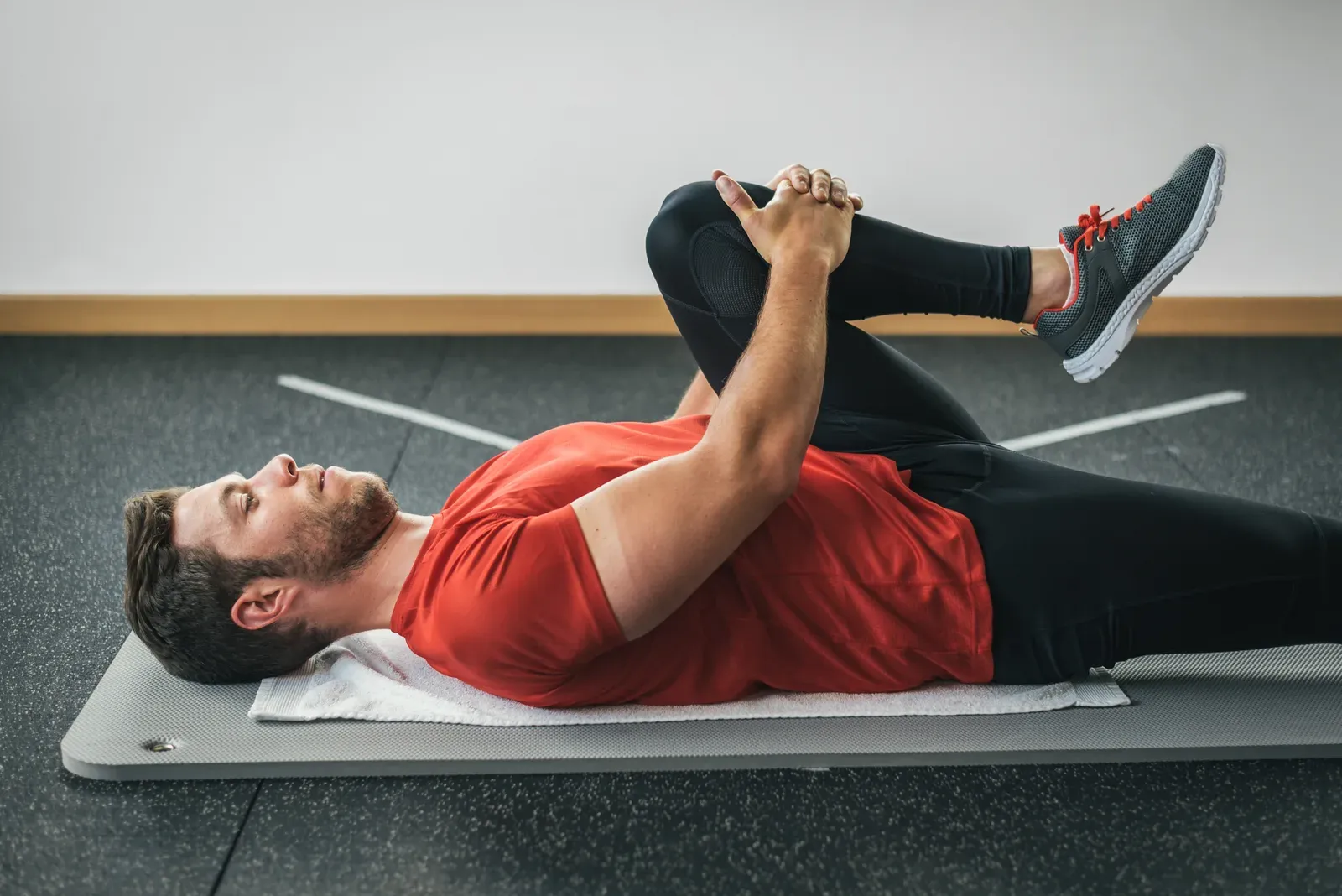 A coach guiding a client through a supported deep lunge stretch