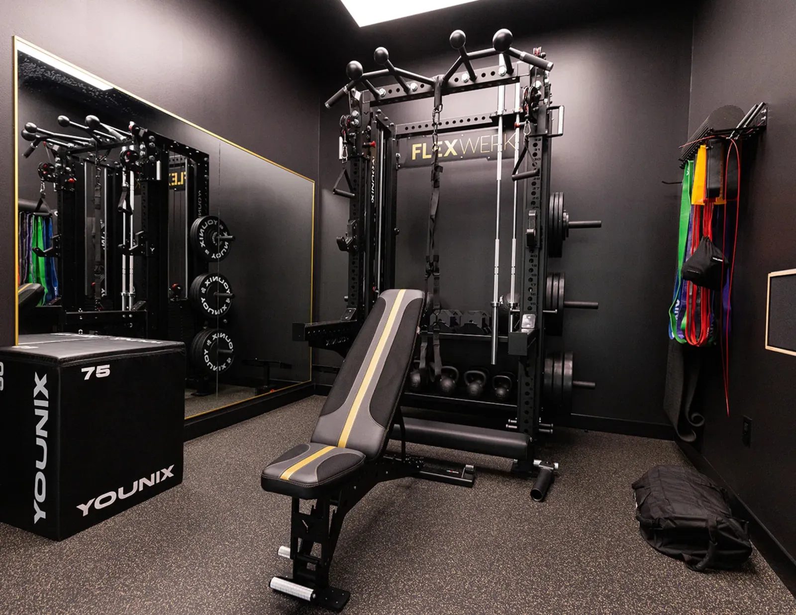 FlexSpace Standard training room at FlexWerk Carmel: functional trainer rack, adjustable bench, resistance bands, and mirror