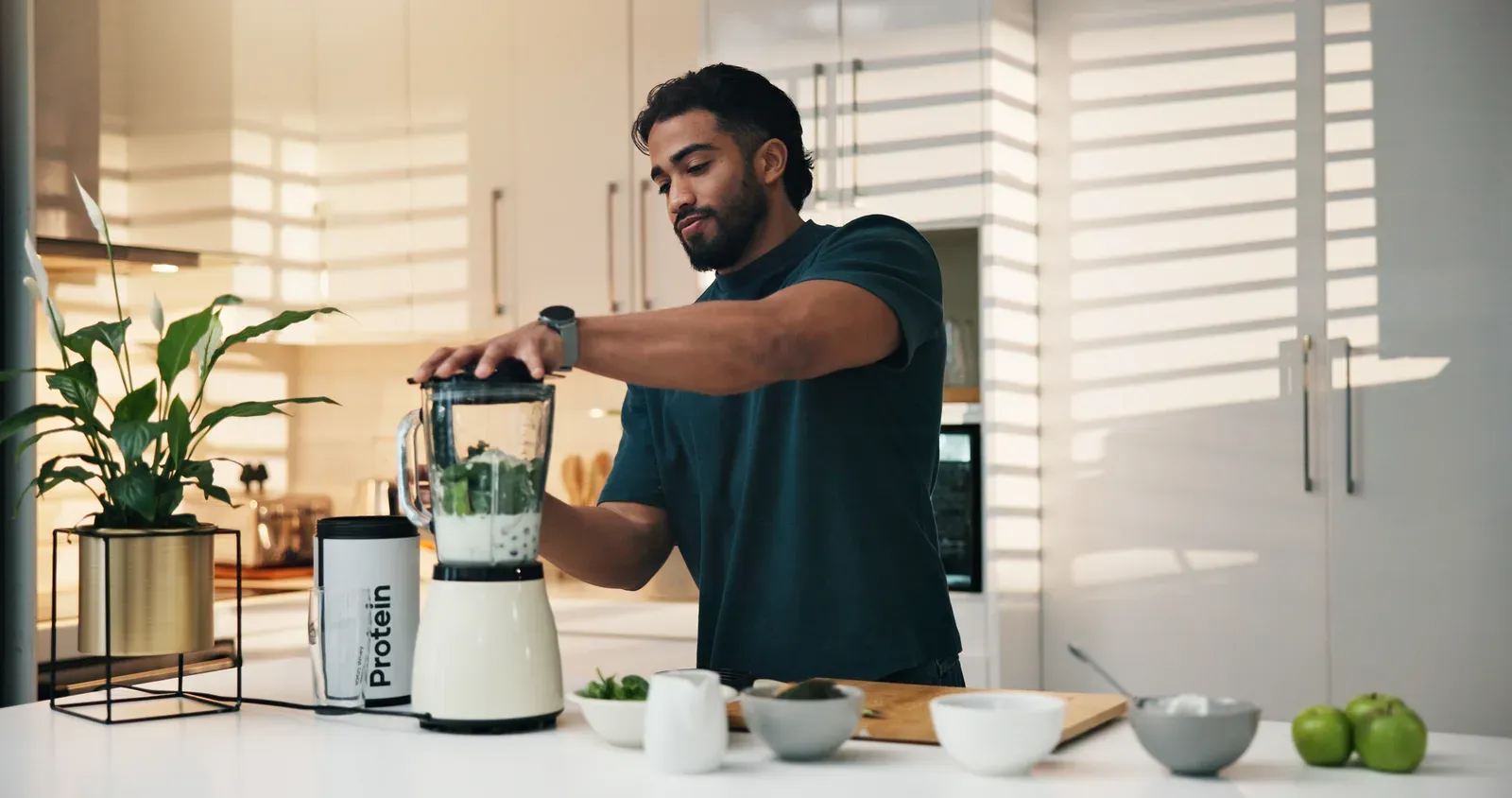 Man at home by a blender making a protein shake for breakfast or a snack, an option when appetite is low