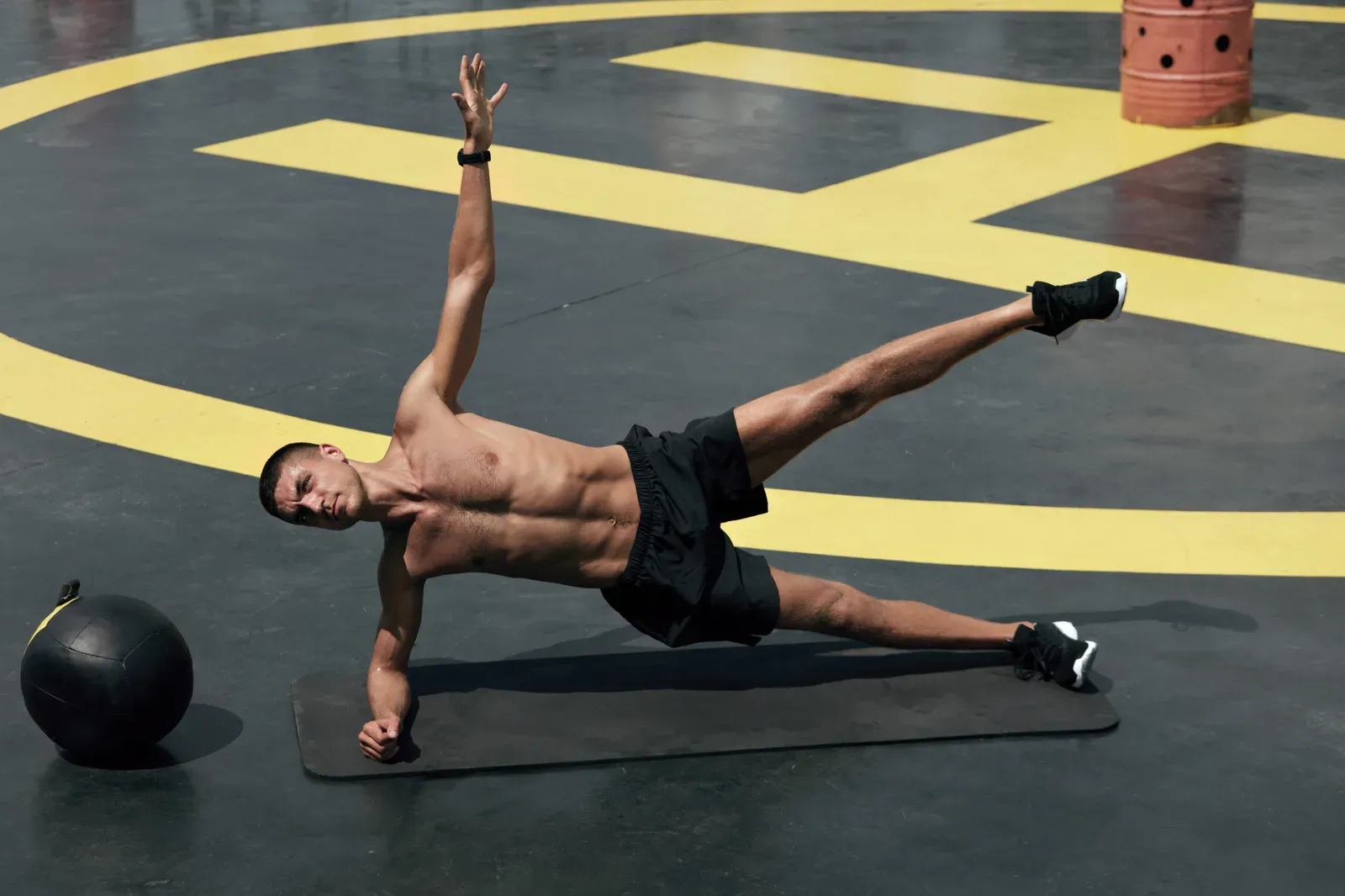 Man doing a side plank at the gym, a core exercise often linked to love handles