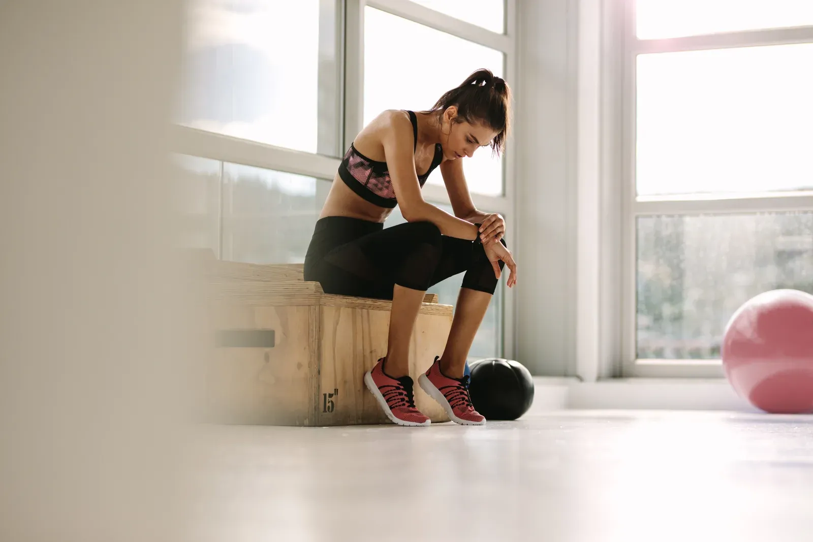 Young woman pausing to rest partway through her gym workout
