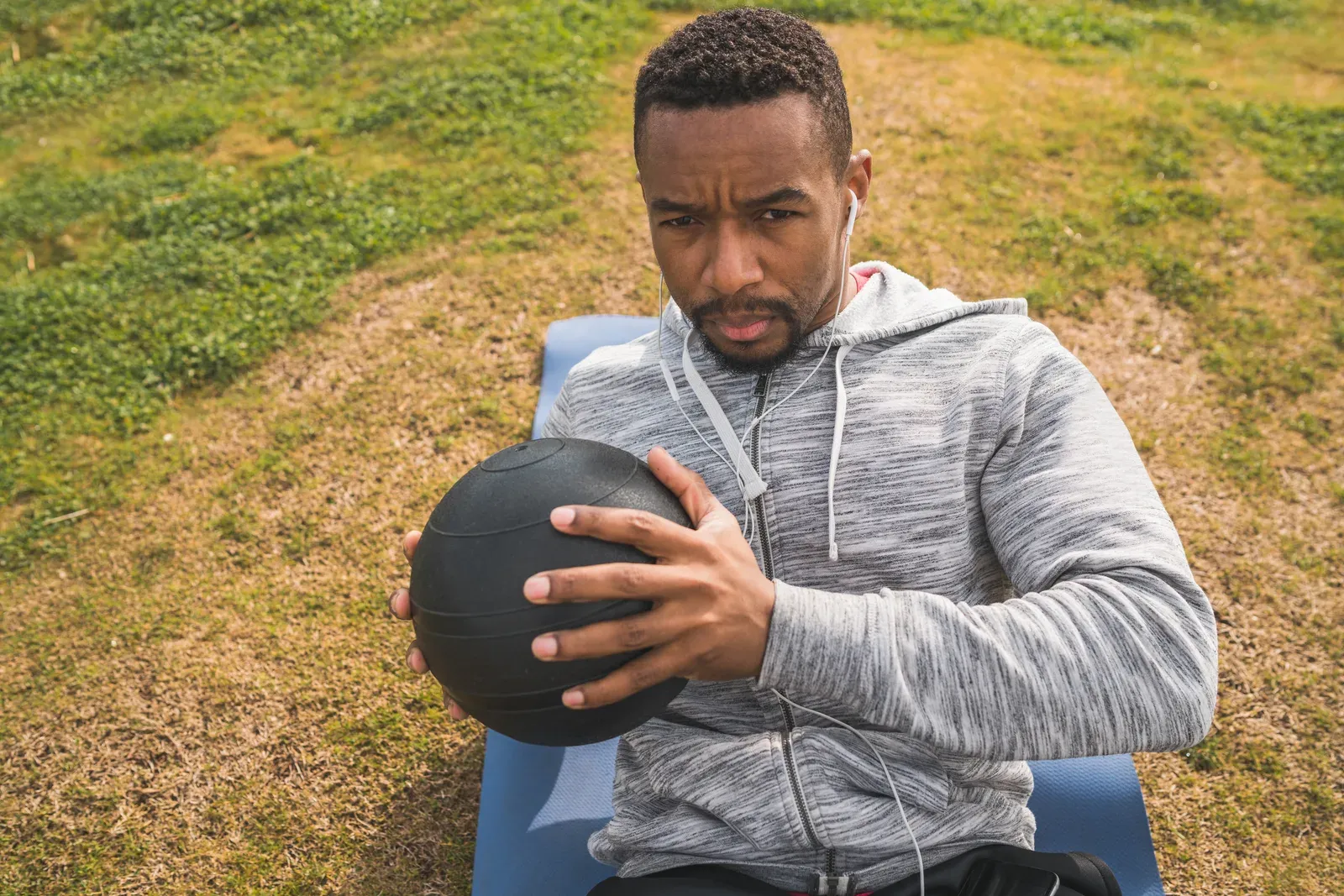 A golfer training with a medicine ball indoors during winter