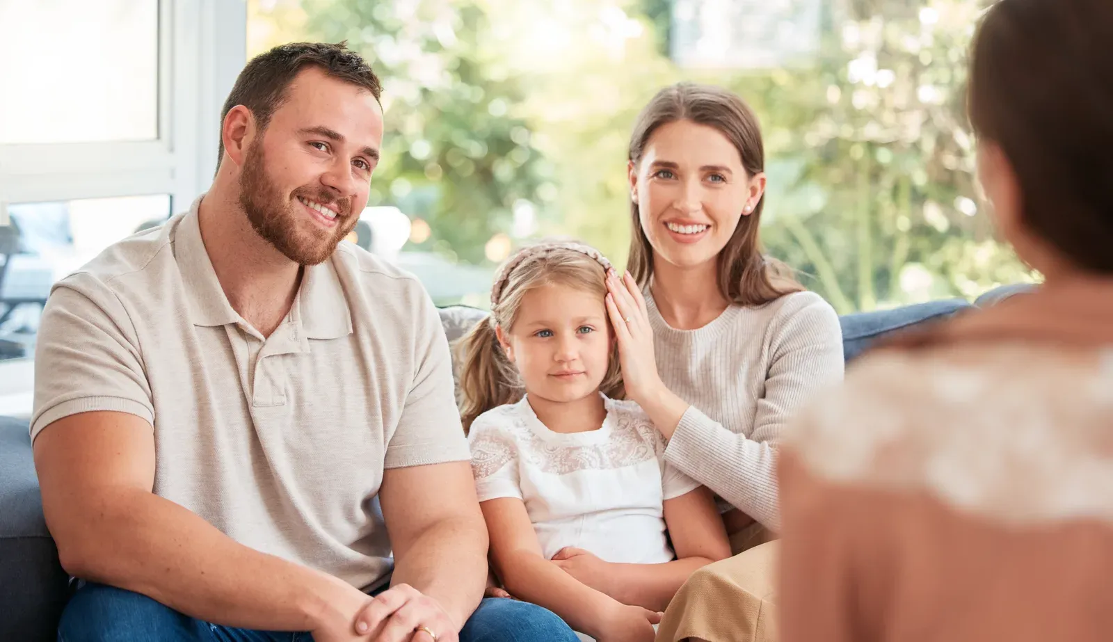 Young family discussing something with a person at home, like being asked to sign up on the spot