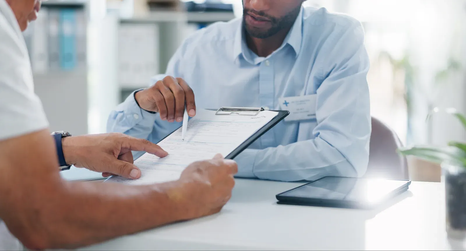 Man and doctor with hands on a form for signature in a hospital consultation, like checking a health plan reimbursement