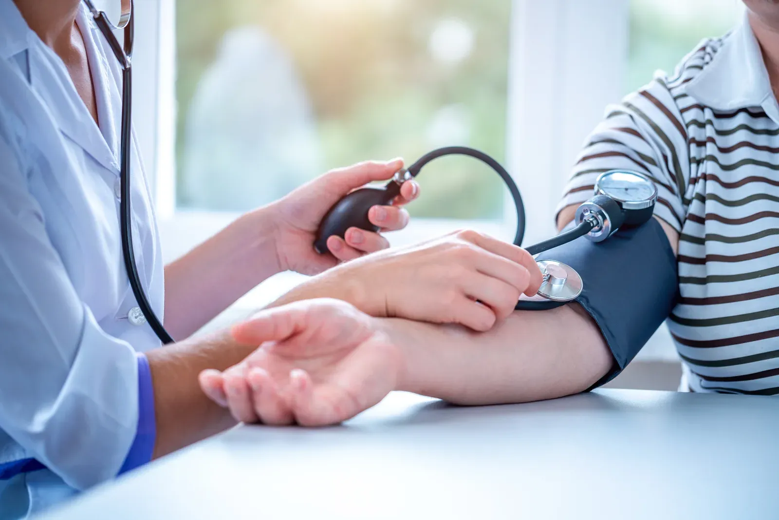 Doctor measuring a patient's blood pressure during a medical consultation