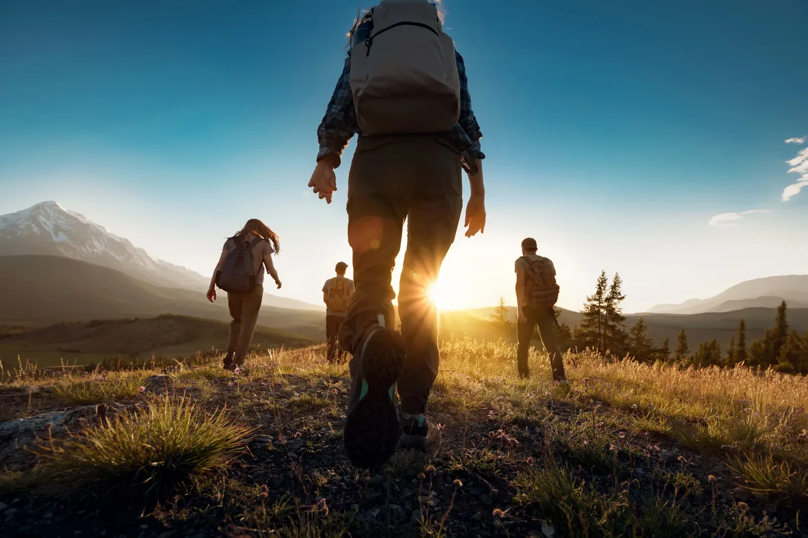 Hiker with a loaded backpack climbing a rocky mountain trail