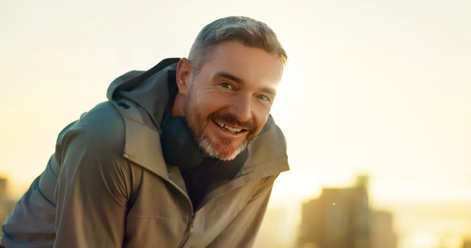 Tired man resting outdoors at sunset after exercise, a sign that overtraining may need attention