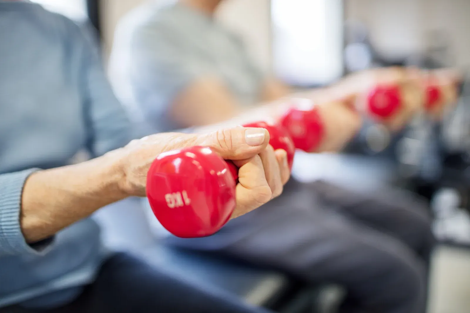 Senior woman lifting a pair of dumbbells to maintain muscle mass