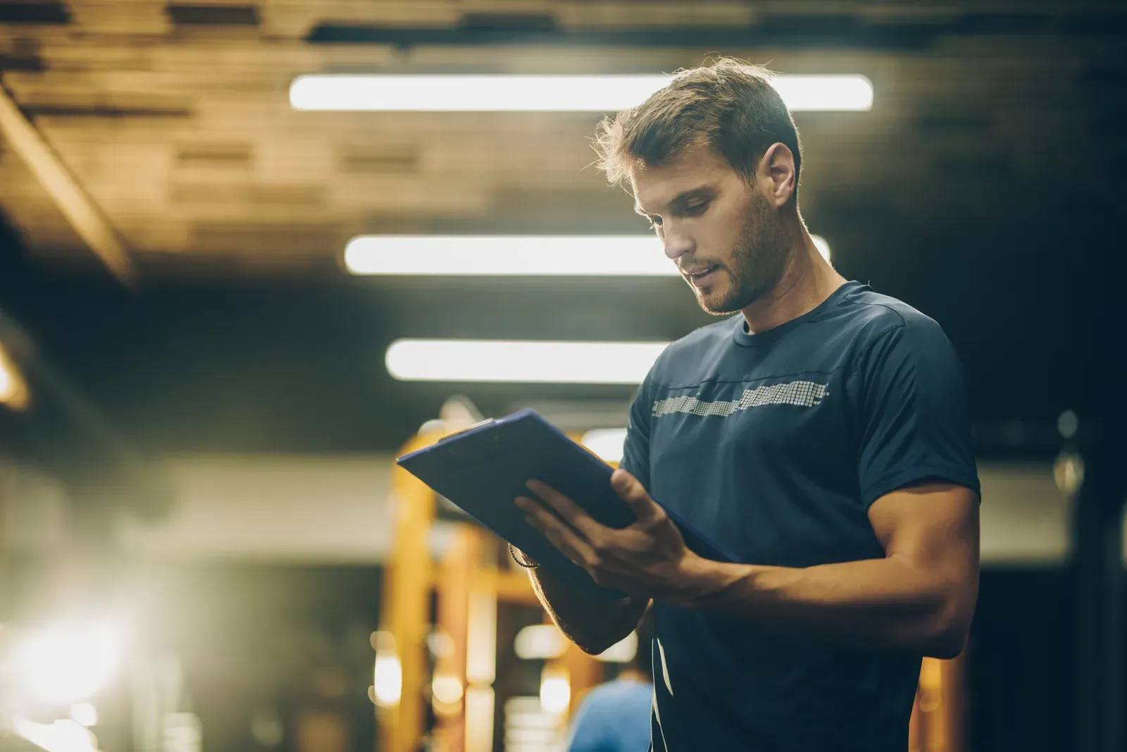 Fitness instructor reviewing a written training plan on the gym floor