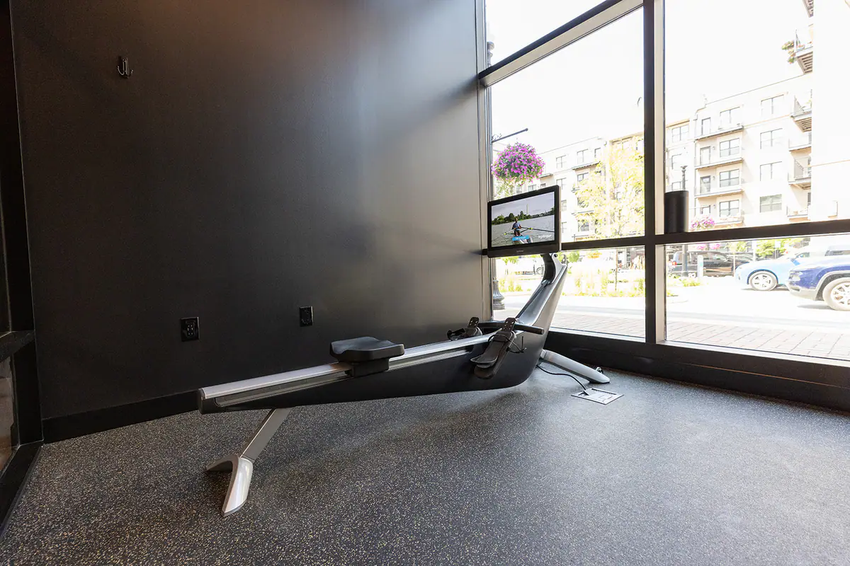 A rowing machine beside the window inside a private FlexWerk cardio suite