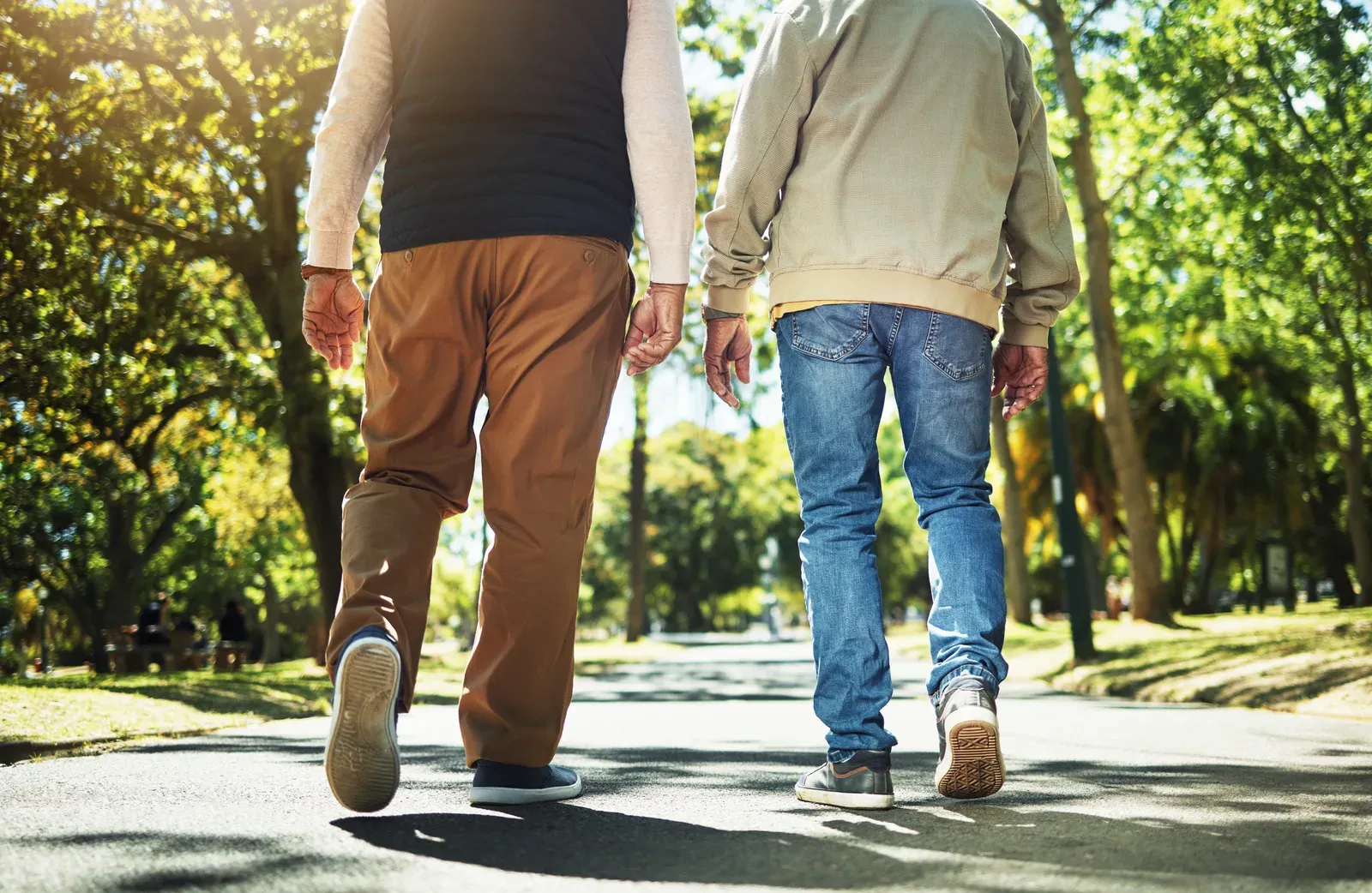 Friends walking a park path together for fresh air and easy cardio