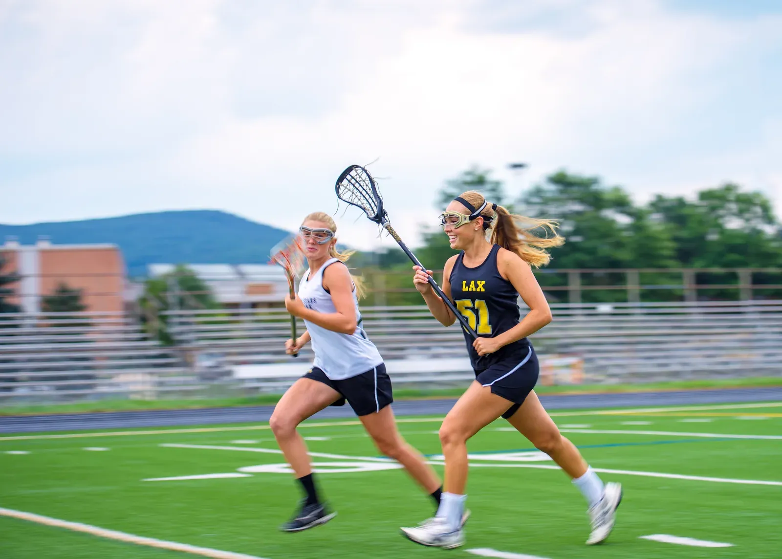 Lacrosse player cradling the ball while sprinting past a defender