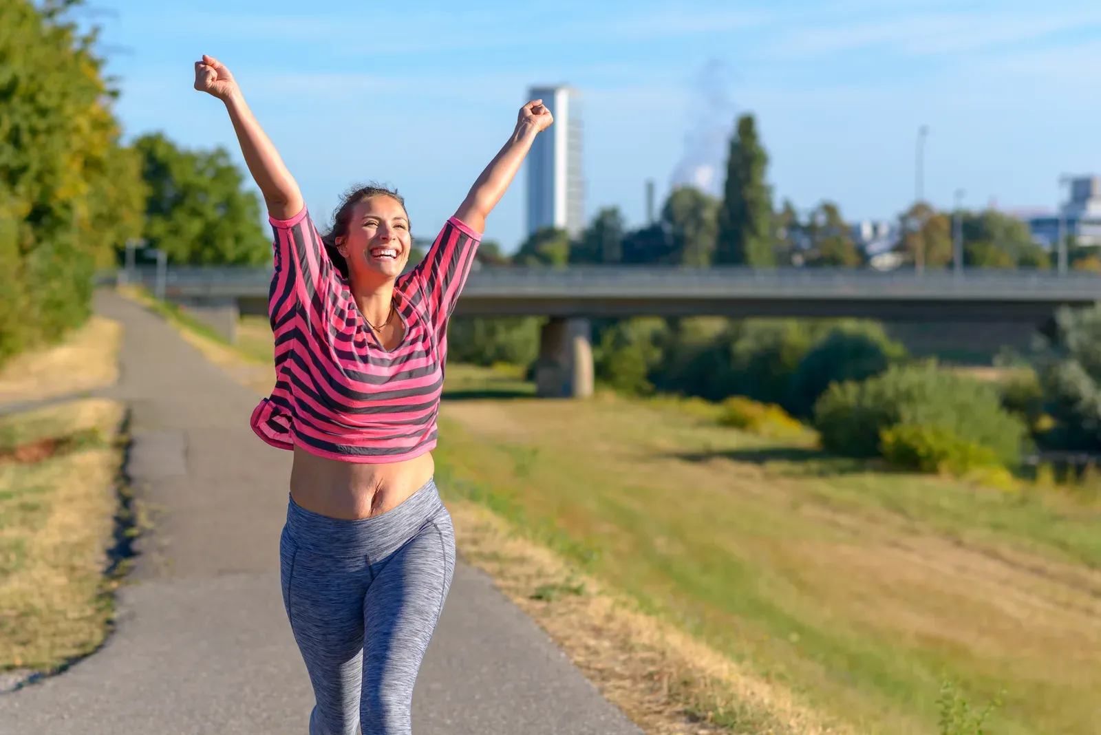 Happy fit woman cheering and celebrating, a milestone moment on the path to losing 50 pounds