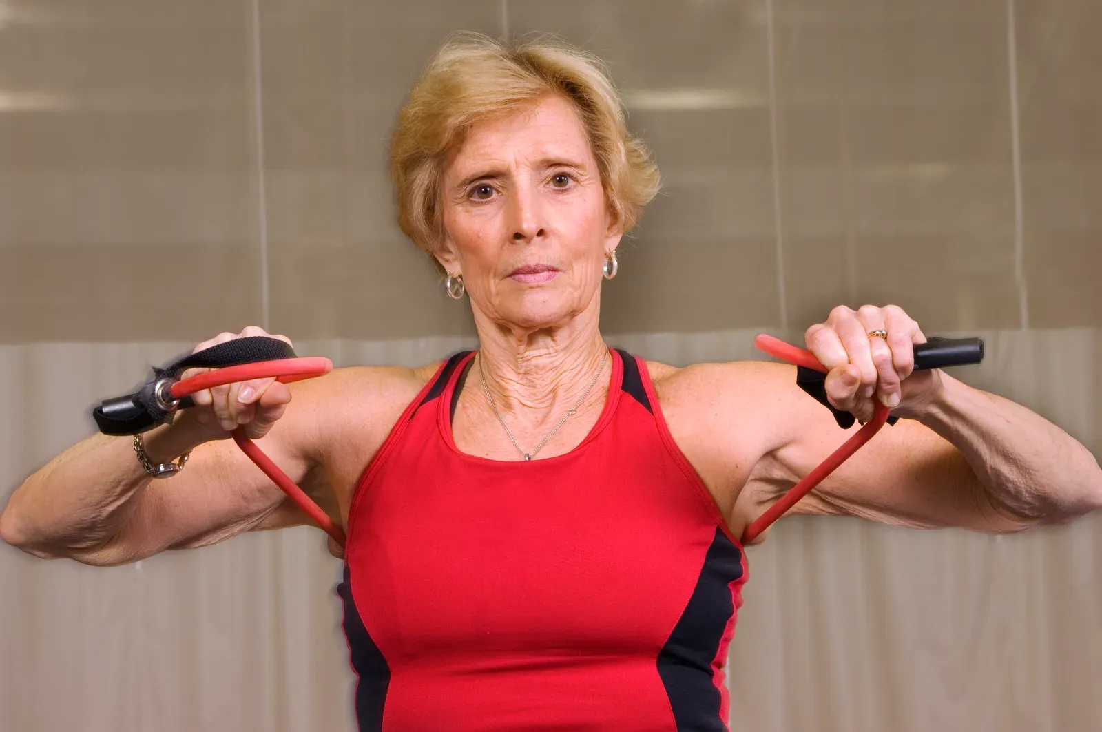 Trainer coaching a middle aged client through a controlled cable exercise