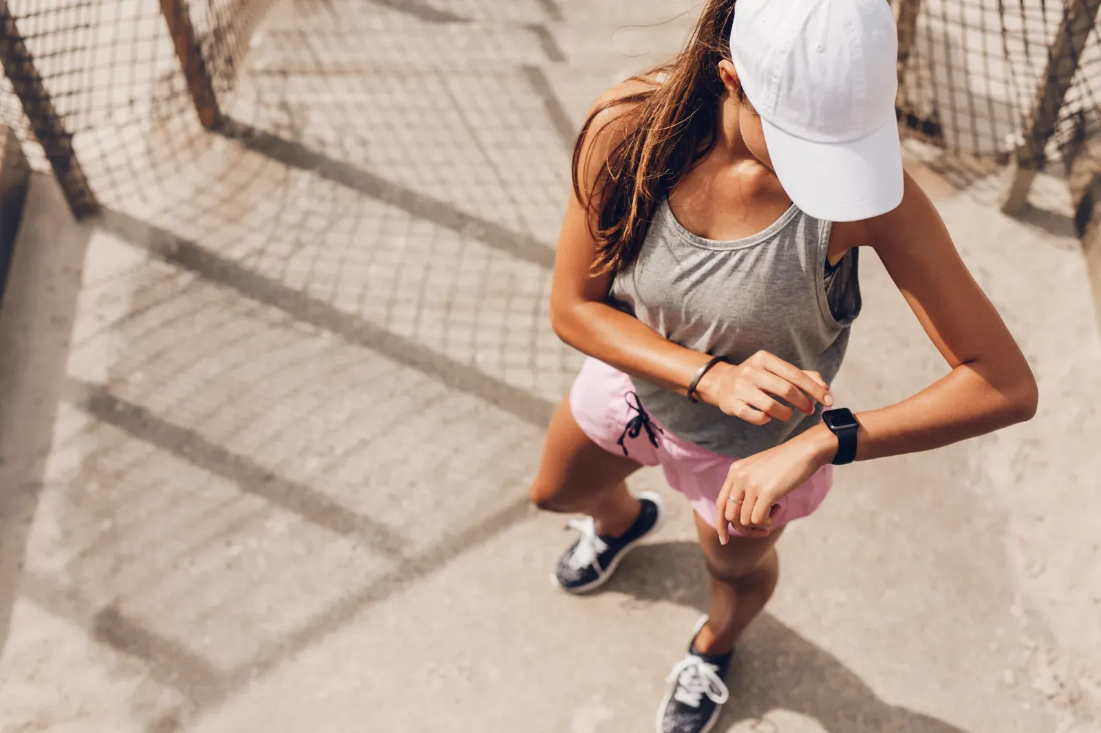 Female runner checking a smart watch heart rate monitor, useful during a marathon taper