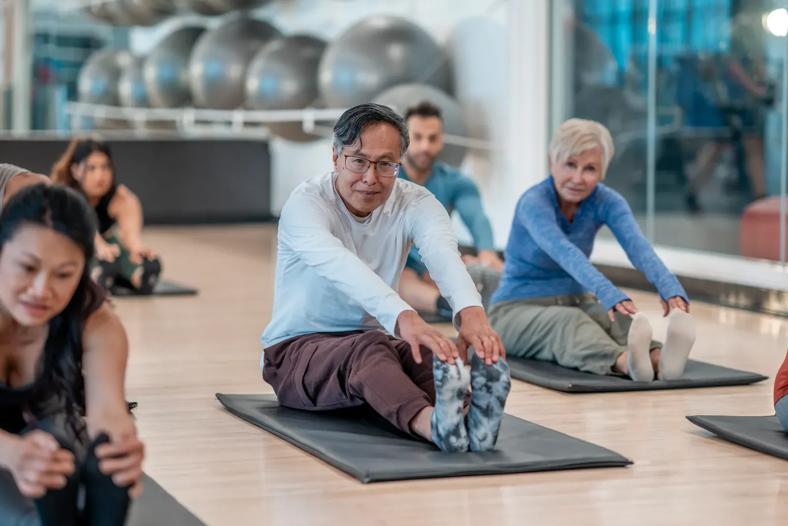 Adults stretching together in a group fitness class