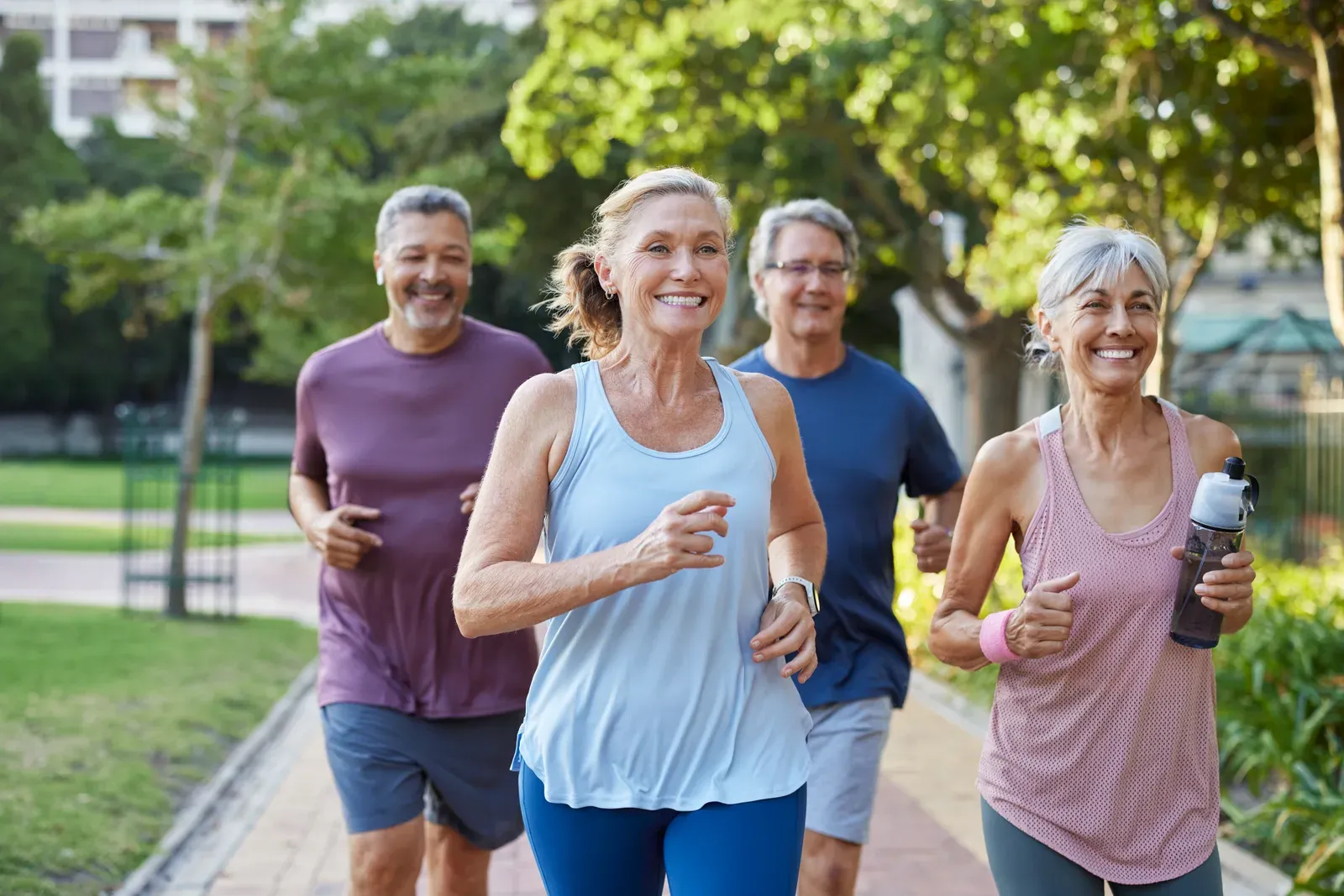 Healthy older adults jogging together in the park, keeping their metabolism active
