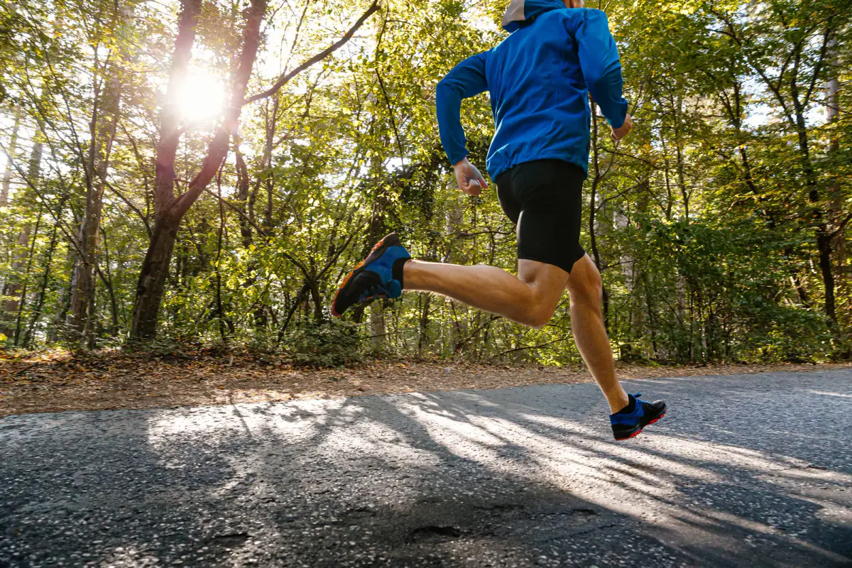 A runner on a tree lined paved greenway trail