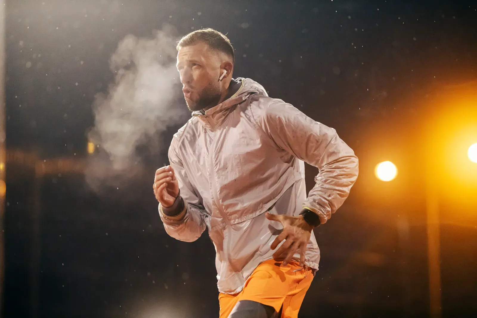 Urban runner out on a snowy city street at night