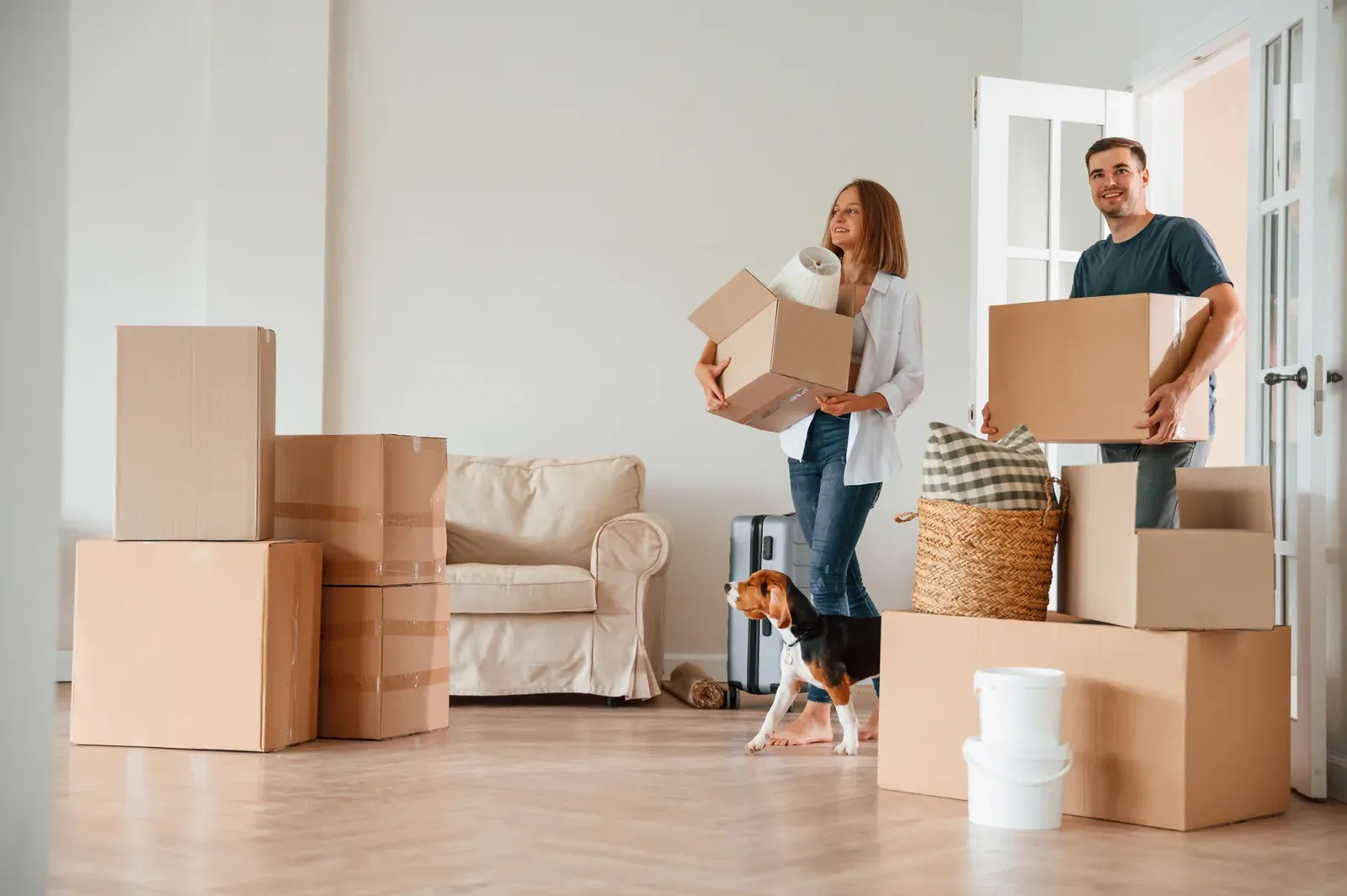 Young couple with a dog walking forward with moving boxes, a move that may affect a training contract