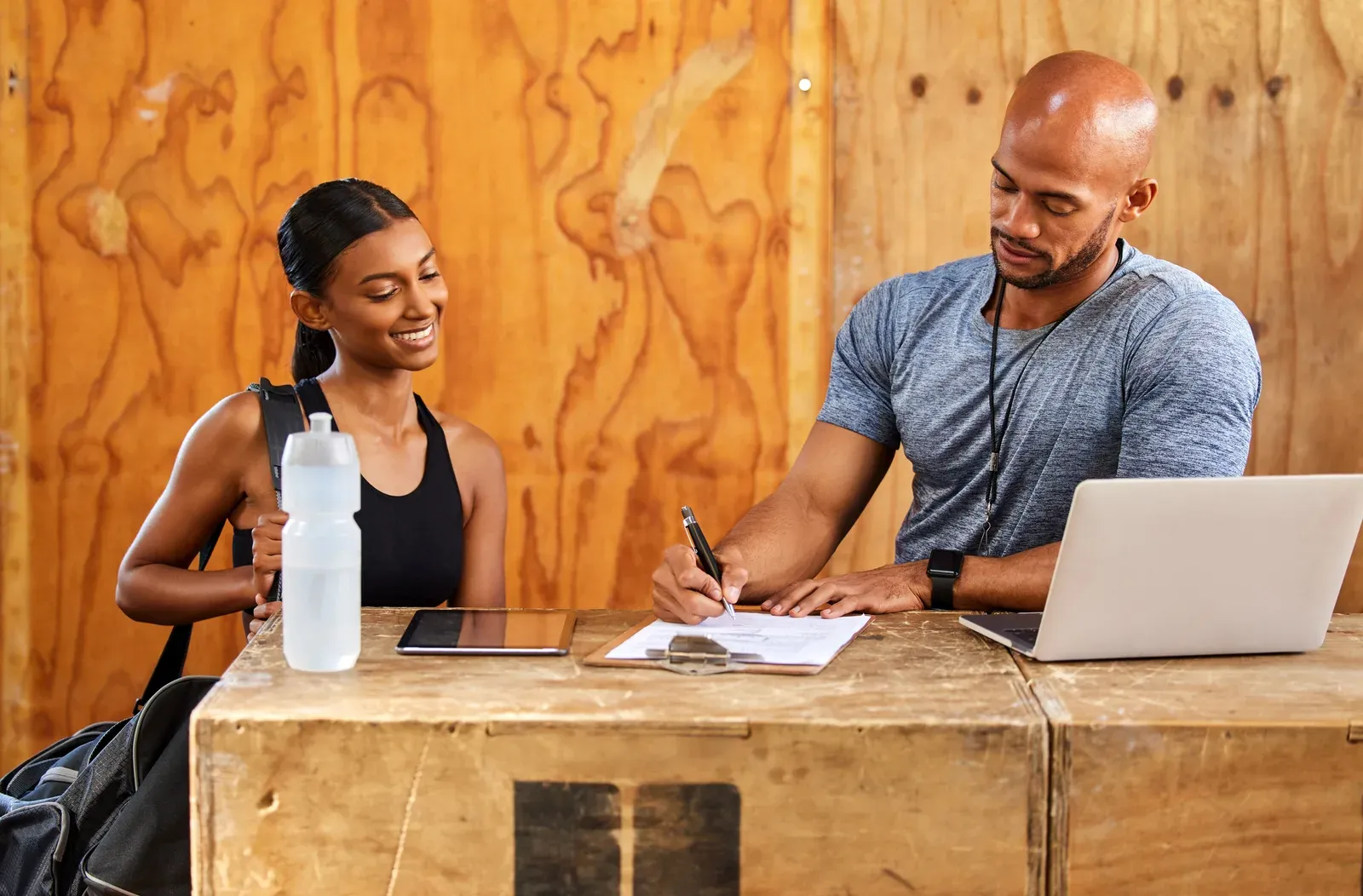 Person confidently declining paperwork across a desk, gym bag at their feet