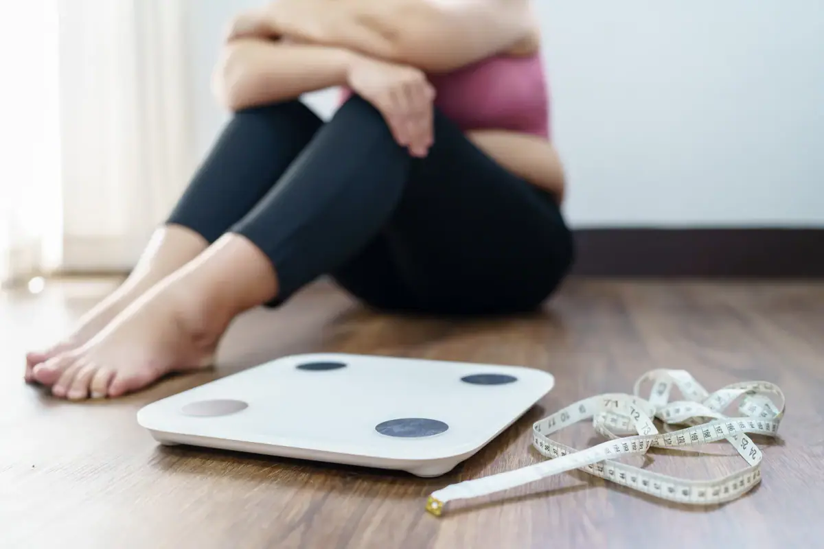 Frustrated woman checking the number on her home bathroom scale